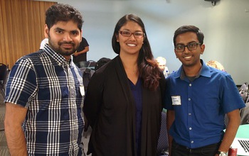 Three people standing in a classroom